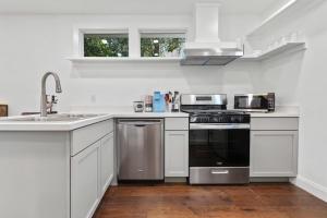 a white kitchen with a sink and a stove at Coastal Cabana Studio - Close to beach and Mississippi City in Gulfport