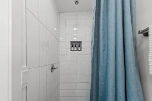 a bathroom with a shower with a blue shower curtain at Coastal Cabana Studio - Close to beach and Mississippi City in Gulfport
