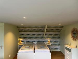 a bedroom with two beds and a stone wall at Vakantiehuis 't Geultje in Schin op Geul +34 photos