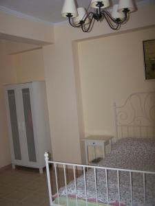 a bedroom with a bed and a chandelier at Eirini Apartment in Nea Kalikratia +6 photos