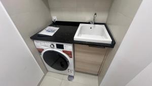 a small bathroom with a sink and a washing machine at Paradisus guest house in Caniço +28 photos
