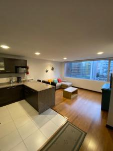 a large kitchen and living room with a couch at Finlandia Park Suite in Quito