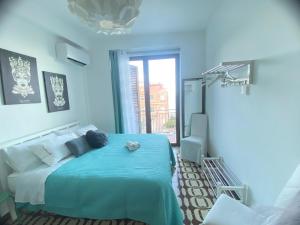 a blue bedroom with a bed and a window at TaorminaCentre Panorama in Taormina