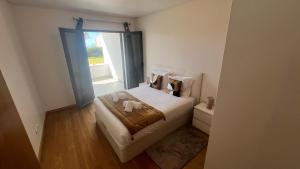 a small bedroom with a bed and a window at Paradisus guest house in Caniço