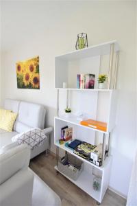 ein weißes Bücherregal in einem Wohnzimmer mit Sofa in der Unterkunft Ferienwohnung Kube in Grömitz