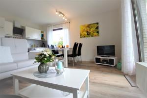 ein Wohnzimmer mit einer weißen Couch und einem Tisch in der Unterkunft Ferienwohnung Kube in Grömitz