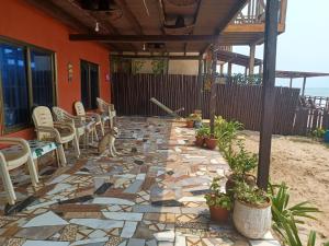 a stone patio with chairs and a dog sitting on it at Adinam's Beach Retreat in Nyanyanu +10 photos