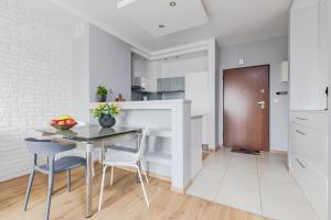 Una cocina y un comedor con mesa y sillas. en Apartament Kiedacza, darmowy parking, en Varsovia