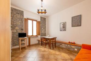 a living room with a table and a tv at Podere La Grande Quercia in Rosignano Marittimo