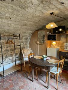 a kitchen and dining room with a table and chairs at Sous la Glycine in Giverny