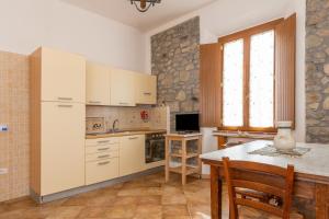 a kitchen with white cabinets and a table at Podere La Grande Quercia in Rosignano Marittimo