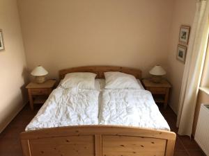 a bedroom with a bed with two nightstands and two lamps at Dycke Haus 6 in Garz-Rügen