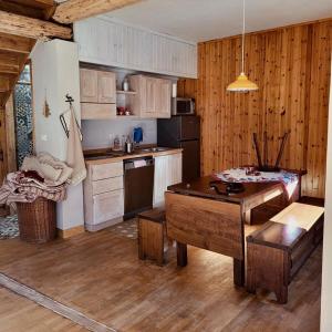 a kitchen with wooden cabinets and a table in it at La Quë Dou Queur in Cantoira
