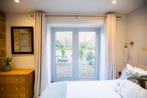 a bedroom with a bed and a sliding glass door at Mowhay Barn in Bodmin
