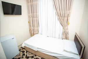 a small bedroom with a bed and a window at Tiny House Hotel in Samarkand