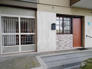 a building with two garage doors and a red door at Casa Acqua Marina in Bisceglie