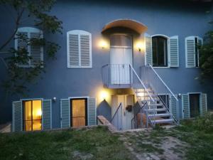 a blue house with a staircase in front of it at Glam One Bedroom Duplex in Vila in city centre in Arad