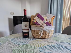 a bottle of wine and a basket on a table at Casa Araflo in Cortijada Los Chorreros