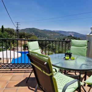 a table and chairs on a balcony with a view of a pool at Casa Araflo in Cortijada Los Chorreros
