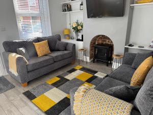 a living room with a couch and a fireplace at Archie's Cottage in Lincoln