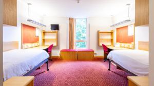 爱丁堡Summer Stays at The University of Edinburgh的一间有两张床、几张桌子和一扇窗户的房间