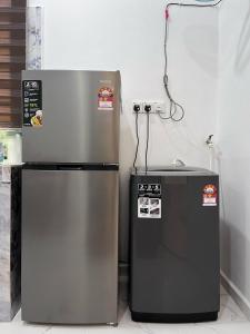 two refrigerators sitting next to each other in a kitchen at AF Barokah Homestay Unit 2 , Kuala Terengganu in Kuala Terengganu
