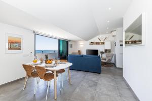 a dining room and living room with a table and chairs at CoralMar Beachfront Apartment -Stunning Ocean Views -Algarve in Armação de Pêra