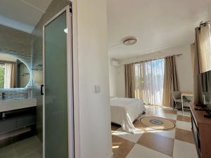a hotel room with a bed and a bathroom at V&V Apartment in Belle Mare
