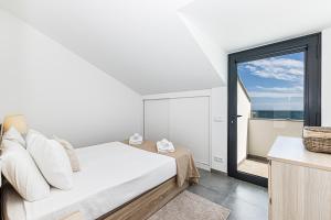a bedroom with a bed and a large window at CoralMar Beachfront Apartment -Stunning Ocean Views -Algarve in Armação de Pêra