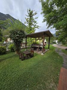 a picnic shelter with a picnic table in the grass at Casa Ornella in Ledro