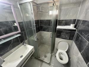 a bathroom with a shower and a toilet and a sink at Yıldırım Otel in Didim +19 photos