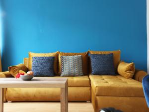 a living room with a brown couch with blue walls at Gainsborough Place By N And N Stays, Perfect for Contractors and Workers Visiting Cardiff, Pvt Off Road Parking, Close to Cardiff Bay & international sports village, long stay disc available, Fast Wifi in Cardiff