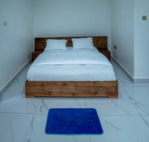 a bedroom with a bed with a blue rug on the floor at Holly apartment in Kigali
