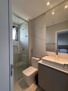 a bathroom with a toilet and a sink and a shower at Apartamento 100m da Praia Brava - Itajaí in Itajaí