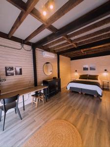 a bedroom with a bed and a desk and a table at Herco Suites in Traiguén