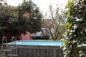 a swimming pool in a yard with a chair and trees at Garden Villa - Villa con frutteto nei pressi del Lago di Como in Olgiate Comasco