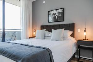 Un dormitorio con una gran cama blanca con dos lámparas. en Perla Beautiful Apartment, en Buenos Aires 102 fotos más