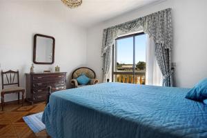 ein Schlafzimmer mit einem blauen Bett und einem Fenster in der Unterkunft Vivenda Ribeiro - B in Lagos