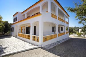 ein weißes Haus mit einem orangefarbenen Dach in der Unterkunft Vivenda Ribeiro - B in Lagos