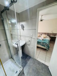 a bathroom with a shower and a sink and a bed at ApartSur Santa Fe in Santa Fe +38 photos