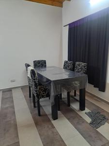 a dining room table with chairs and a black curtain at Apartment for 2 people - Erezcano one in Adrogué