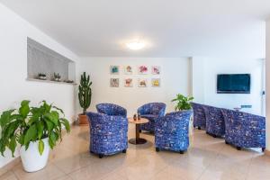 a waiting room with blue chairs and a table at Hotel San Giacomo in Cesenatico