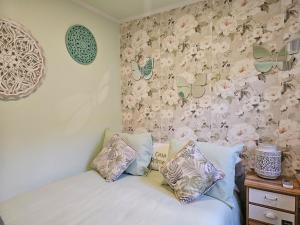 Un dormitorio con una cama con flores en la pared. en Casa Romeu by Sesimbra Sun Sea, en Sesimbra