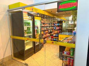 a grocery store aisle with a refrigerator in a store at STAY Sun Square in Goiânia