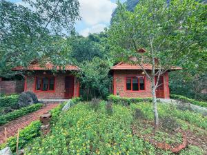 a small red brick house in a garden at Chinh Thu Garden Retreat in Ninh Binh