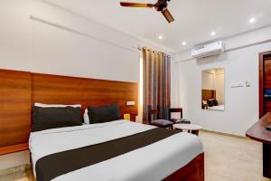 a bedroom with a large bed and a desk at Collection O Airport Inn in Bangalore +24 photos
