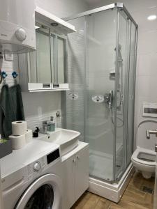 a bathroom with a shower and a washing machine at Apartman NS FREE PARKING in Novi Sad +12 photos