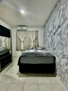 a bedroom with a bed and a stone wall at Casa em Condomínio em Mangaratiba in Mangaratiba +45 photos