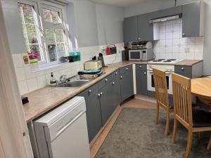 a kitchen with grey cabinets and a table and chairs at Symonds Yat West Holiday Cottage 8 WRC with views of Yat Rock in Symonds Yat