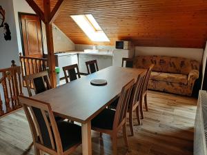 a kitchen and dining room with a wooden table and chairs at 11 féröhelyes apartman in Balatonlelle